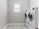 Convenient laundry room with modern washer and dryer and window at 18696 Malinche Loop, Spring Hill, FL 34610