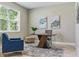 Comfortable home office featuring a unique desk, blue chair, and soothing artwork at 18696 Malinche Loop, Spring Hill, FL 34610