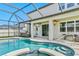 Backyard pool with a screened-in enclosure and outdoor seating at 18696 Malinche Loop, Spring Hill, FL 34610