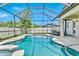 Inviting screened-in pool area with a clear blue pool, comfortable seating, and lush greenery at 18696 Malinche Loop, Spring Hill, FL 34610