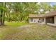 Expansive back yard with mature trees, a patio with outdoor seating, and room to roam at 19555 Phillips Rd, Brooksville, FL 34604