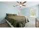 Bedroom with ceiling fan, closet, window, and large bed with green quilt at 19555 Phillips Rd, Brooksville, FL 34604