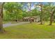 Charming single-Gathering home features a spacious front yard with mature trees and a two car garage at 19555 Phillips Rd, Brooksville, FL 34604