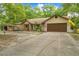 Charming exterior of the home with mature landscaping, American flag and extended driveway at 19555 Phillips Rd, Brooksville, FL 34604
