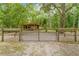 Gated horse arena with a covered shelter and sturdy wooden fencing at 19555 Phillips Rd, Brooksville, FL 34604