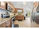 Bright kitchen featuring stainless steel appliances, tile backsplash, granite countertops, and light-colored tile flooring at 19555 Phillips Rd, Brooksville, FL 34604
