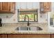 Close-up of the kitchen sink with granite countertops and a window view of the outdoor area at 19555 Phillips Rd, Brooksville, FL 34604