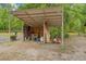 Open storage shed filled with hay bales, tack, and various supplies at 19555 Phillips Rd, Brooksville, FL 34604