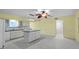 Open kitchen with island, white cabinets, tile floors, and a ceiling fan at 2192 Swedish Dr # 10, Clearwater, FL 33763