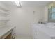 Functional laundry room with washer, dryer, folding table, and shelving at 2192 Swedish Dr # 10, Clearwater, FL 33763