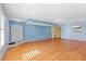 Spacious living room with hardwood floors, large windows, and a modern lighting fixture at 2192 Swedish Dr # 10, Clearwater, FL 33763