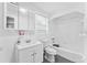 Bathroom features a tub, white tiles, vanity sink, mirrored cabinet and window at 2320 W Walnut St, Tampa, FL 33607
