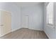 Bright bedroom with wood-look floors, closet, window, and light-blue paint at 2320 W Walnut St, Tampa, FL 33607