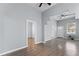 Bright living room with neutral walls, wood-look floors, ceiling fan, and open doorways at 2320 W Walnut St, Tampa, FL 33607