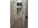 Hallway with neutral walls and carpet flooring leads to a bedroom with natural light at 2332 S Fairway Dr, Plant City, FL 33566