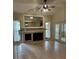 Bright living room featuring a fireplace, ceiling fan, and tile floors, with lots of natural light from the double doors at 2332 S Fairway Dr, Plant City, FL 33566
