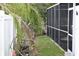 View of a backyard with a screened-in porch, green foliage, and a privacy fence at 2470 Del Rio Way, Dunedin, FL 34698