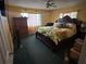 Bedroom with a dark wood bed frame, tropical bedding, and carpet at 2701 W Cherry St, Tampa, FL 33607