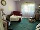 Cozy bedroom with a red chair, white curtains and plenty of natural light at 2701 W Cherry St, Tampa, FL 33607