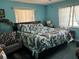 Turquoise bedroom with a queen-sized bed, leaf-patterned bedding and plenty of natural light at 2701 W Cherry St, Tampa, FL 33607
