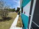 Close-up of front exterior, with turquoise and white stripes, lush lawn at 2701 W Cherry St, Tampa, FL 33607