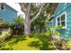 Landscaped backyard featuring artificial turf, a large shade tree, and tropical plants for a serene outdoor retreat at 2709 Upton S St, Gulfport, FL 33711