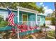 View of the inviting front porch, adorned with an American flag and lush plants at 2709 Upton S St, Gulfport, FL 33711