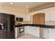 Well-equipped kitchen with stainless steel appliances, white cabinets, and dark countertops at 2718 Chipley Ave, North Port, FL 34286