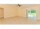 Bright living room with tile flooring, ceiling fan, and sliding door access to the outside at 2718 Chipley Ave, North Port, FL 34286