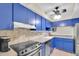 Kitchen features blue cabinets, stainless steel appliances, and speckled countertops at 2943 Bough Ave # C, Clearwater, FL 33760