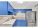 Kitchen showcasing bright blue cabinetry, stainless steel refrigerator, and tile backsplash at 2943 Bough Ave # C, Clearwater, FL 33760