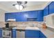 Kitchen featuring blue cabinets, stainless steel appliances, and stone-look backsplash at 2943 Bough Ave # C, Clearwater, FL 33760