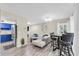 Bright living room with gray wood floors, a white sectional sofa, and adjacent eat-in dining area at 2943 Bough Ave # C, Clearwater, FL 33760
