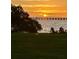 Stunning waterfront view at sunset with mature trees and chairs by the water at 2943 Bough Ave # C, Clearwater, FL 33760