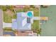 Aerial view of a modern home with a kidney-shaped pool, a wooden dock, and manicured landscaping at 319 Midway Is, Clearwater Beach, FL 33767