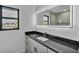 Elegant bathroom with sleek black countertop, vessel sink, illuminated mirror, and contemporary fixtures at 319 Midway Is, Clearwater Beach, FL 33767