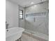 Elegant bathroom featuring a soaking tub and large glass shower with marble tile and a built-in niche at 319 Midway Is, Clearwater Beach, FL 33767