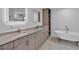 Modern bathroom with a double vanity, soaking tub, and custom cabinetry, offering a luxurious retreat at 319 Midway Is, Clearwater Beach, FL 33767