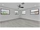 Bright bedroom with laminated floor, three windows and a modern ceiling fan at 319 Midway Is, Clearwater Beach, FL 33767