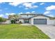 Inviting two-story home boasting a well-manicured lawn, paved driveway, and a stylish gray garage door at 319 Midway Is, Clearwater Beach, FL 33767