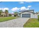 Charming two-story home featuring a gray garage door, a lush lawn, and a well-paved driveway at 319 Midway Is, Clearwater Beach, FL 33767