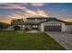 Stunning two-story home with a well-manicured lawn and a modern gray driveway leading to the two-car garage at 319 Midway Is, Clearwater Beach, FL 33767