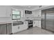 Modern white kitchen with stainless steel appliances, subway tile backsplash, and a farmhouse sink at 319 Midway Is, Clearwater Beach, FL 33767