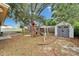 Backyard features a wooden playset, storage shed, and partially covered ground with leaves at 3619 15Th Se Ave, Largo, FL 33771