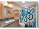 This bathroom features a granite vanity, a shower with a decorative curtain, and floating shelves at 3619 15Th Se Ave, Largo, FL 33771