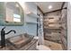 Bathroom featuring a granite countertop, wicker mirror, modern shower with wood tile, and floating shelves at 3619 15Th Se Ave, Largo, FL 33771
