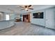 Open-concept living room with wood floors, ceiling fan, a large TV, and a table with seating for entertaining at 3619 15Th Se Ave, Largo, FL 33771