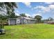 Spacious backyard with a well-maintained lawn, mature trees, and a partially fenced perimeter at 36725 Arcadia Ave, Myakka City, FL 34251