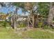 Chicken coop in a fenced area of the yard, surrounded by green grass, flowers and small white fencing at 36725 Arcadia Ave, Myakka City, FL 34251