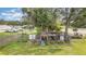 Backyard featuring a large chicken coop with surrounding green space and mature trees at 36725 Arcadia Ave, Myakka City, FL 34251
